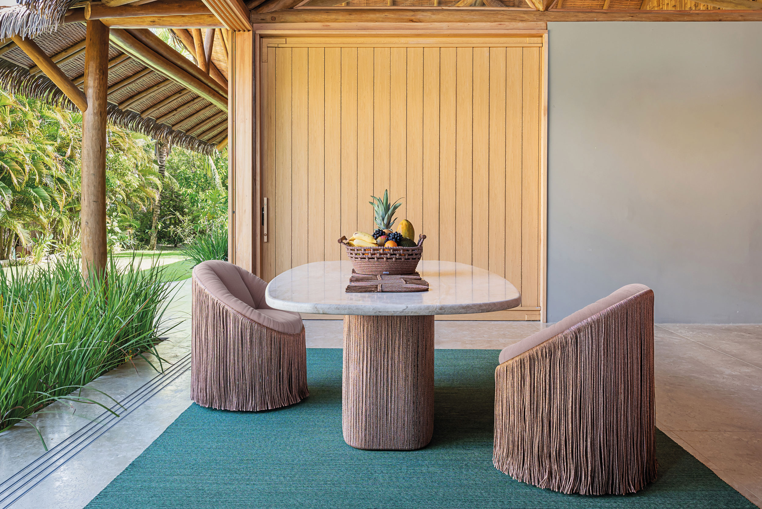 Rope-woven outdoor lounge furniture on a terrace overlooking the ocean
